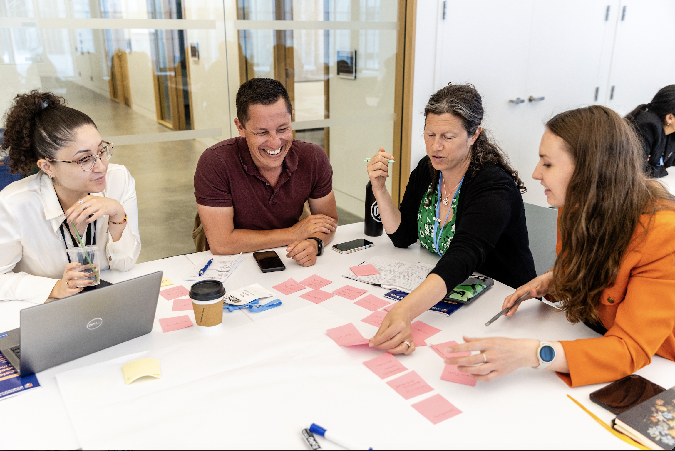 Four people using sticky notes on a table