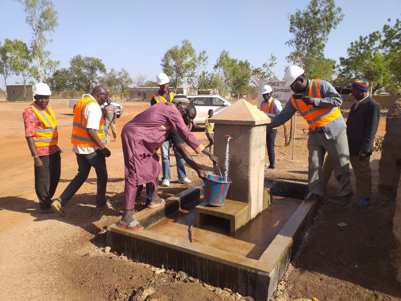 A group of people pumping water