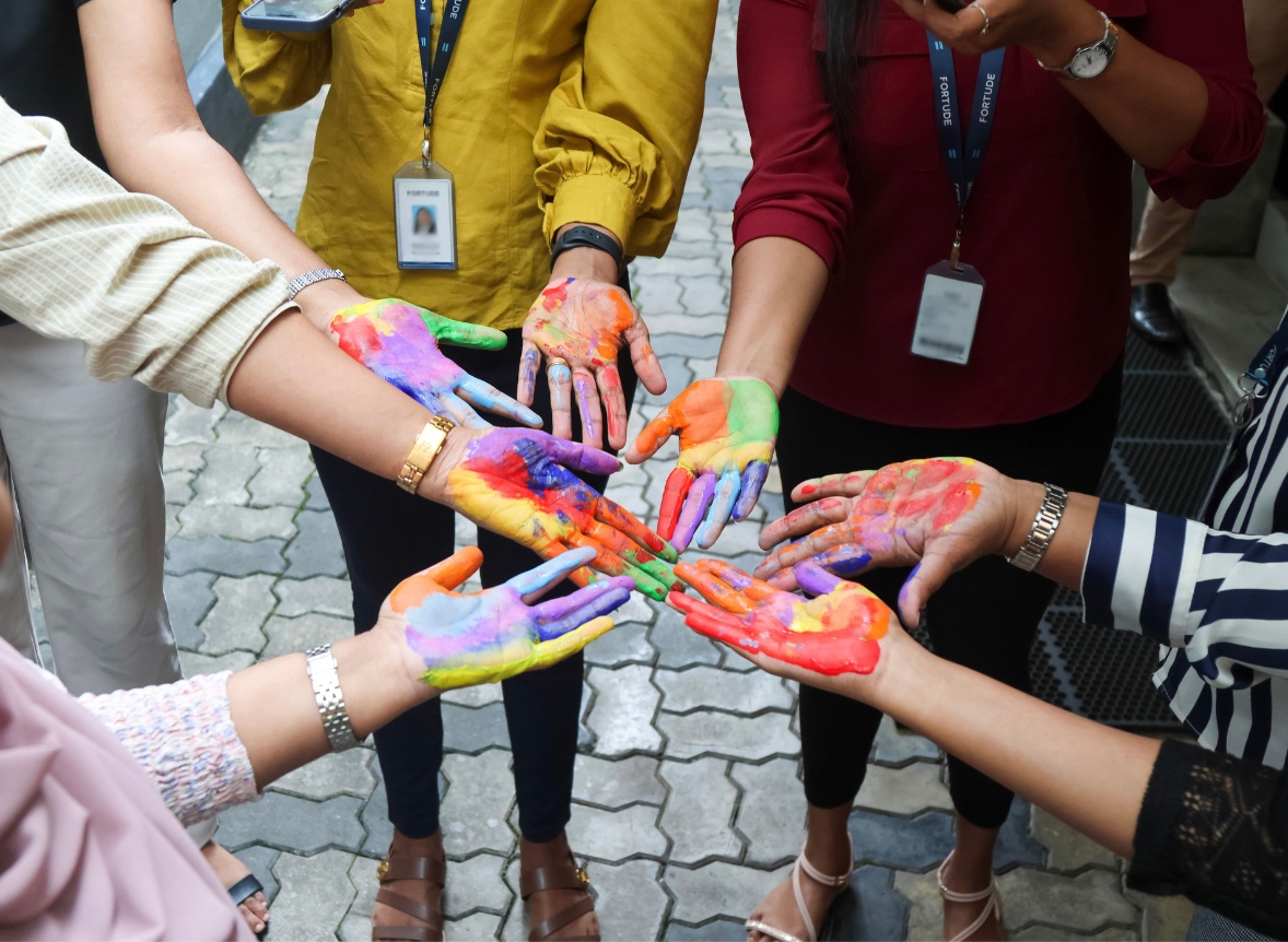A group of people showing their paint-covered hands