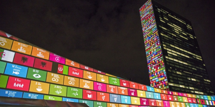 UN building with SDG flags at night