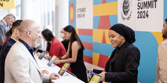 Leaders Summit Check-In Counter with smiling individuals