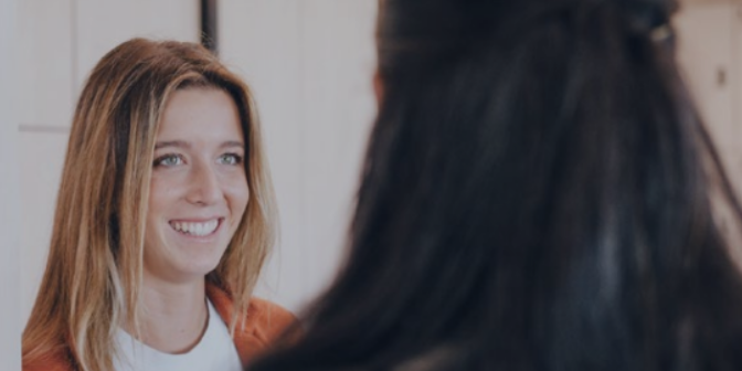 one woman smiling at another woman