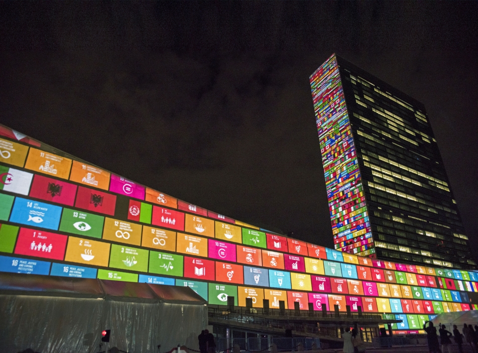 UN building with SDG flags at night