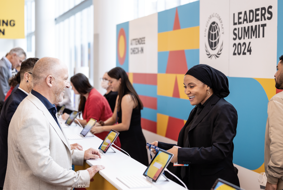 Leaders Summit Check-In Counter with smiling individuals