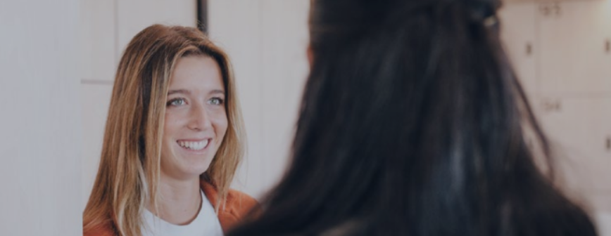 one woman smiling at another woman