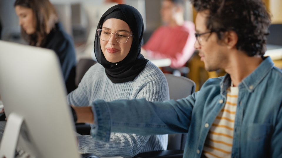young professionals looking at computer screen 