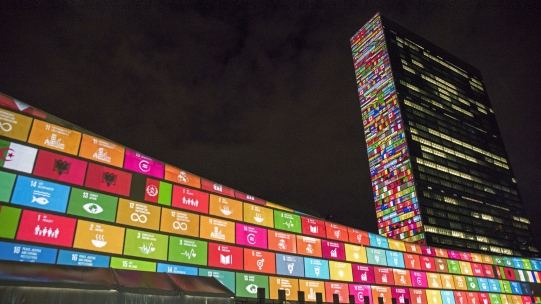 UN building with SDG flags at night