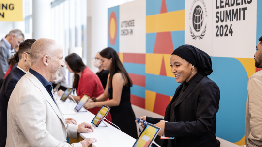 Leaders Summit Check-In Counter with smiling individuals
