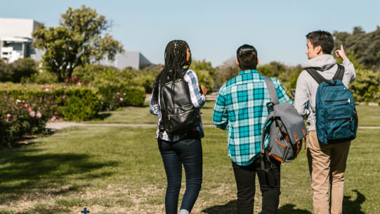 Three students walking outside in nature